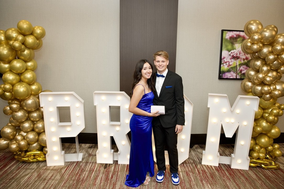 Couple in front of PROM marquee letters